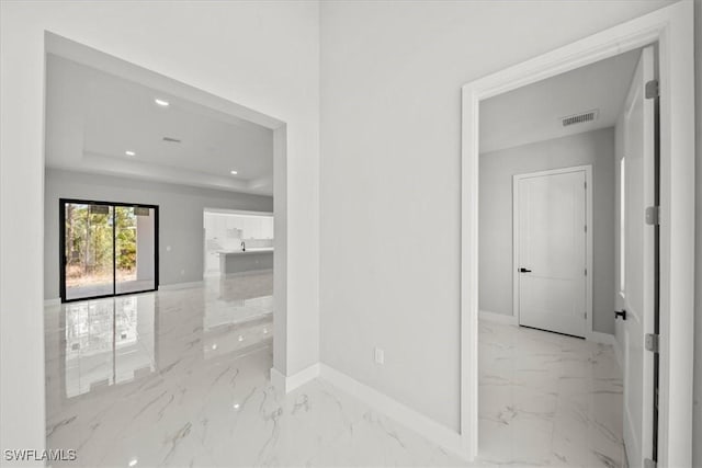 203 E 10th St, Lehigh Acres, FL 33972 - corridor with marble tiled floors, baseboards, recessed lighting, and a raised ceiling