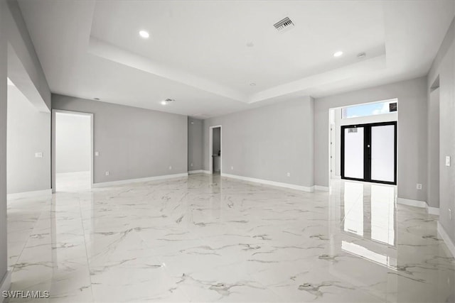 203 E 10th St, Lehigh Acres, FL 33972 - spare room featuring a raised ceiling, recessed lighting, light marble finish flooring, and baseboards