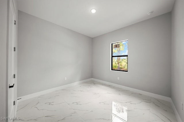 203 E 10th St, Lehigh Acres, FL 33972 - spare room with baseboards, marble finish flooring, and recessed lighting