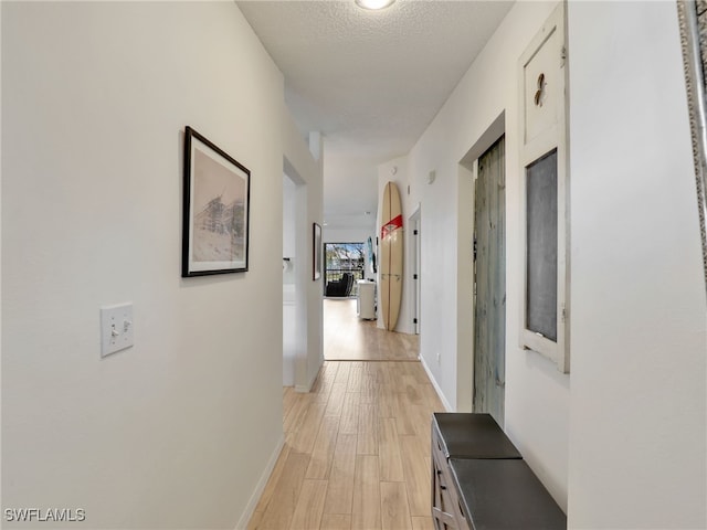 935 New Waterford Dr Unit F204, Naples, FL 34104 - hall featuring baseboards, light wood-style floors, and a textured ceiling