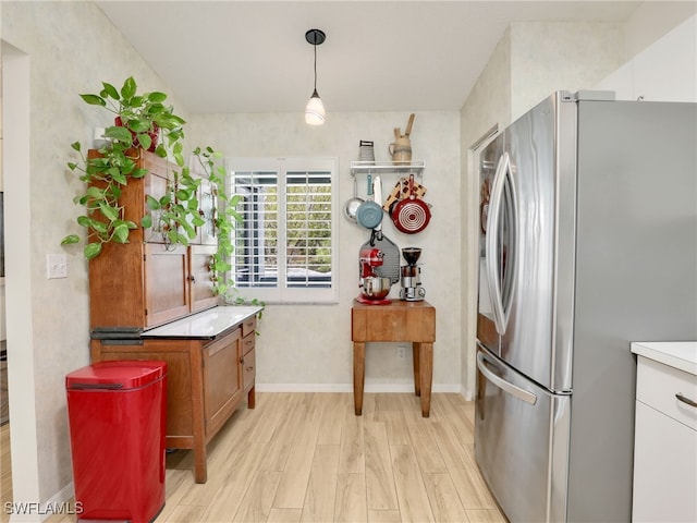 935 New Waterford Dr Unit F204, Naples, FL 34104 - kitchen featuring freestanding refrigerator, light wood finished floors, light countertops, hanging light fixtures, and baseboards