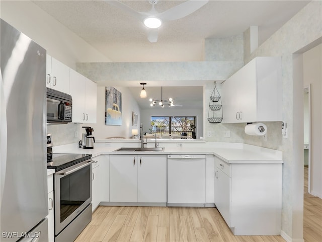 935 New Waterford Dr Unit F204, Naples, FL 34104 - kitchen featuring light wood-style flooring, stainless steel appliances, a sink, light countertops, and white cabinets