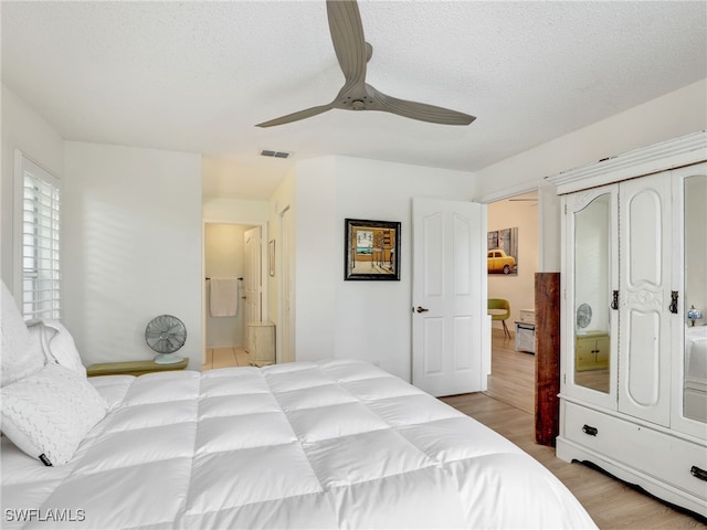 935 New Waterford Dr Unit F204, Naples, FL 34104 - bedroom featuring a ceiling fan, light wood finished floors, visible vents, and a textured ceiling
