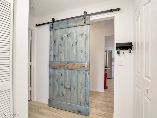 935 New Waterford Dr Unit F204, Naples, FL 34104 - hall with a barn door, baseboards, and wood finished floors