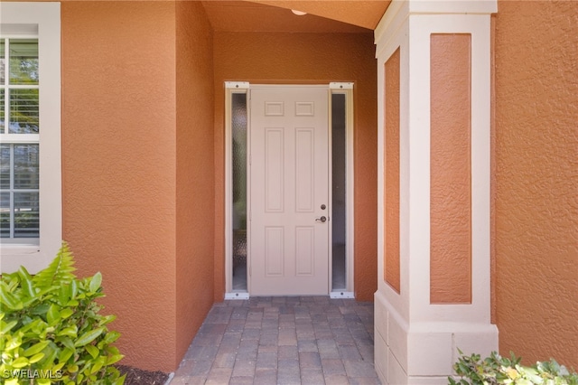 entrance to property featuring stucco siding