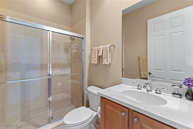 bathroom featuring toilet, vanity, and a stall shower