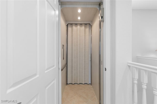 hallway with light tile patterned flooring, elevator, and recessed lighting