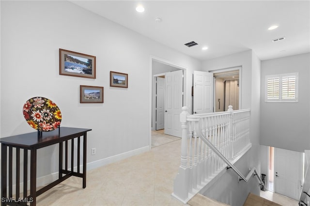 corridor with baseboards, recessed lighting, an upstairs landing, and visible vents