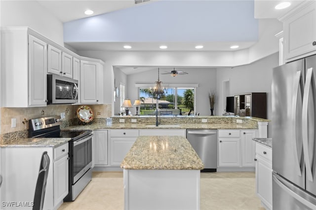 kitchen with a peninsula, recessed lighting, appliances with stainless steel finishes, and a sink