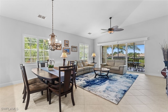 dining area featuring lofted ceiling, light tile patterned floors, baseboards, visible vents, and ceiling fan with notable chandelier
