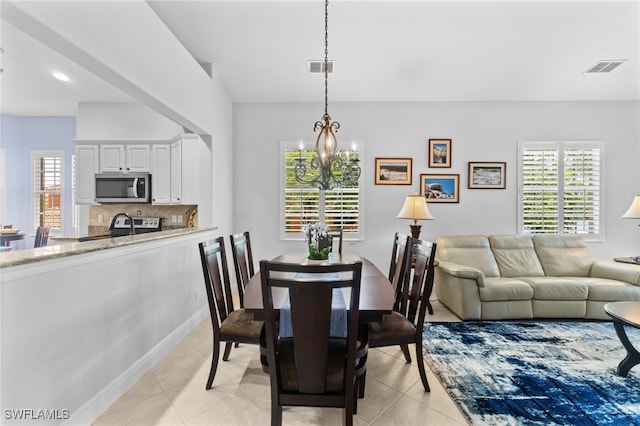 dining area featuring visible vents, an inviting chandelier, and light tile patterned flooring