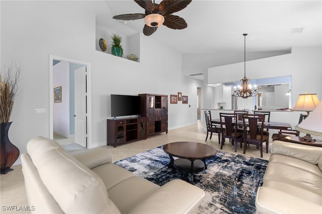 living area featuring light tile patterned floors, baseboards, visible vents, ceiling fan with notable chandelier, and high vaulted ceiling