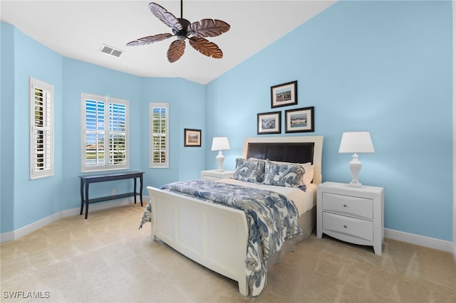 bedroom featuring a ceiling fan, light carpet, visible vents, baseboards, and vaulted ceiling