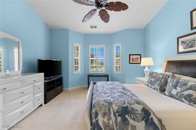 bedroom featuring a ceiling fan, light carpet, baseboards, and visible vents
