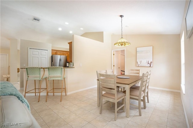 dining area featuring light tile patterned floors, baseboards, lofted ceiling, and visible vents