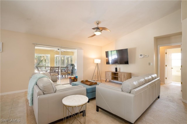 living area with baseboards, a ceiling fan, and lofted ceiling