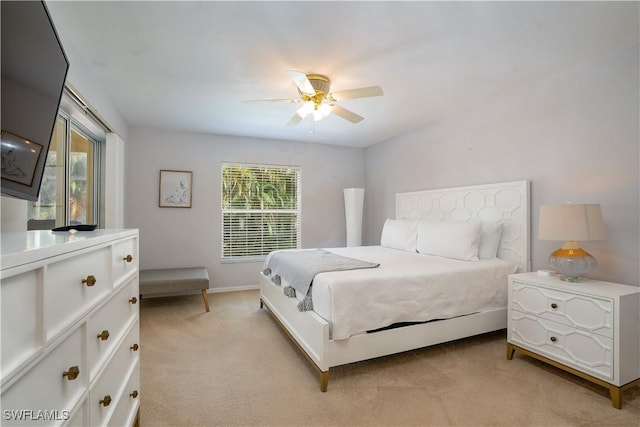 bedroom featuring light colored carpet and a ceiling fan