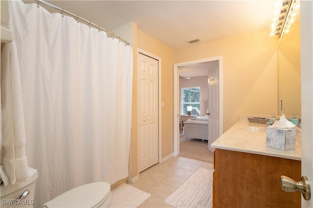 bathroom featuring visible vents, vanity, toilet, baseboards, and tile patterned floors