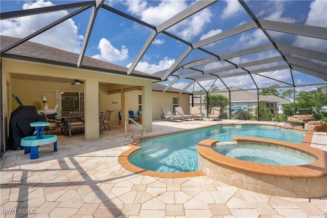 view of swimming pool with a lanai, ceiling fan, a pool with connected hot tub, and a patio area