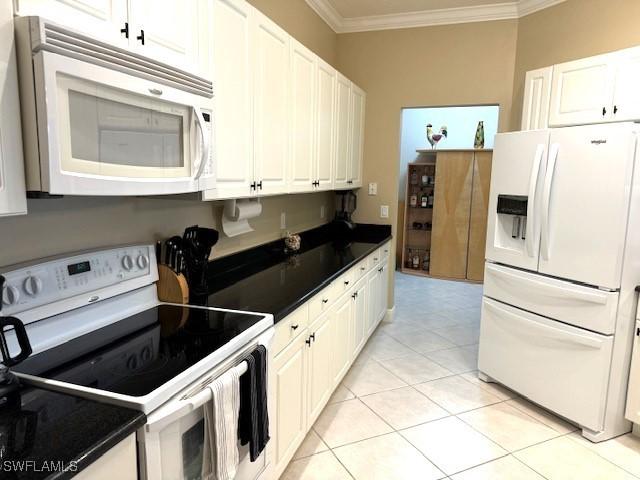2743 1st St Unit 305, Fort Myers, FL 33916 - kitchen featuring ornamental molding, dark countertops, light tile patterned floors, and white appliances