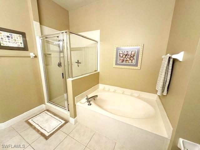2743 1st St Unit 305, Fort Myers, FL 33916 - bathroom with tile patterned floors, baseboards, a garden tub, and a stall shower