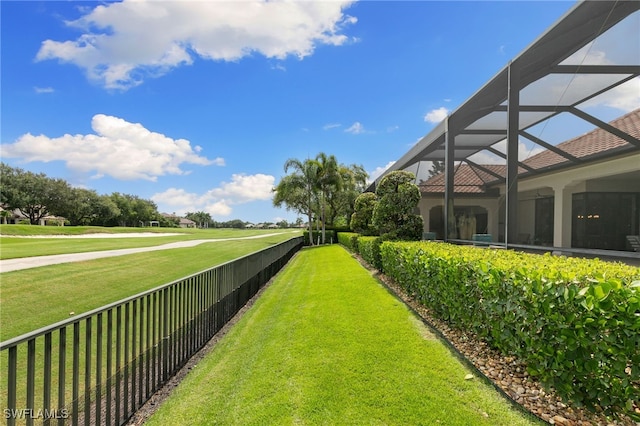 view of yard with fence and glass enclosure