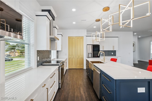 8605 Inwood Dr, Hudson, FL 34667 - kitchen featuring stainless steel appliances, blue cabinets, dark wood-style flooring, white cabinets, and decorative backsplash