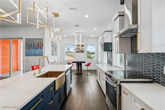 8605 Inwood Dr, Hudson, FL 34667 - kitchen featuring wall chimney exhaust hood, stainless steel appliances, white cabinetry, dark wood-style floors, and recessed lighting