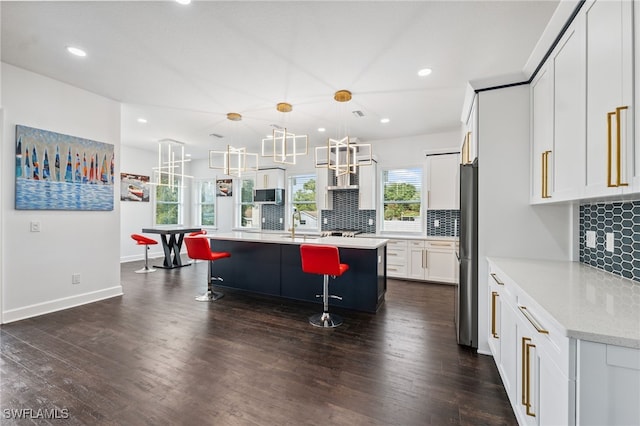 8605 Inwood Dr, Hudson, FL 34667 - kitchen featuring appliances with stainless steel finishes, a kitchen bar, backsplash, white cabinets, and recessed lighting