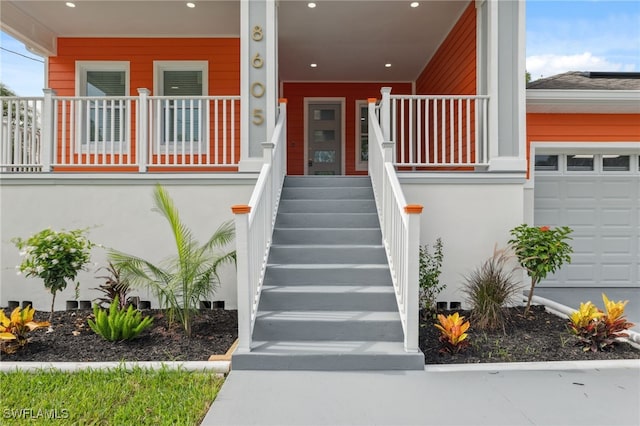 8605 Inwood Dr, Hudson, FL 34667 - view of exterior entry featuring a porch and a garage