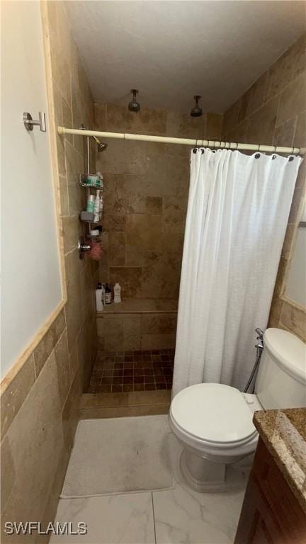 1005 E Penn Rd, Lehigh Acres, FL 33936 - bathroom featuring vanity, a tile shower, toilet, and tile walls