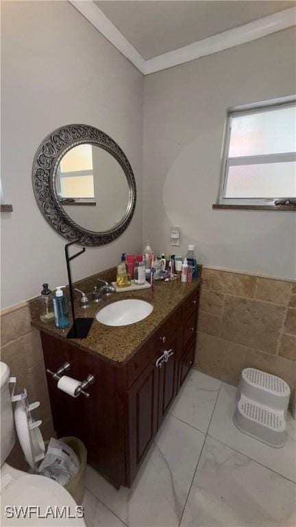 1005 E Penn Rd, Lehigh Acres, FL 33936 - half bathroom featuring crown molding, vanity, toilet, and tile walls