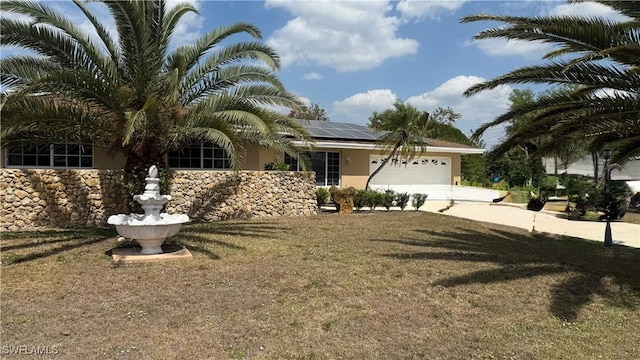 1005 E Penn Rd, Lehigh Acres, FL 33936 - view of front facade with a garage, a front lawn, stucco siding, concrete driveway, and solar panels