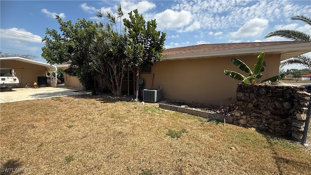 1005 E Penn Rd, Lehigh Acres, FL 33936 - view of yard featuring central AC, an attached carport, and concrete driveway