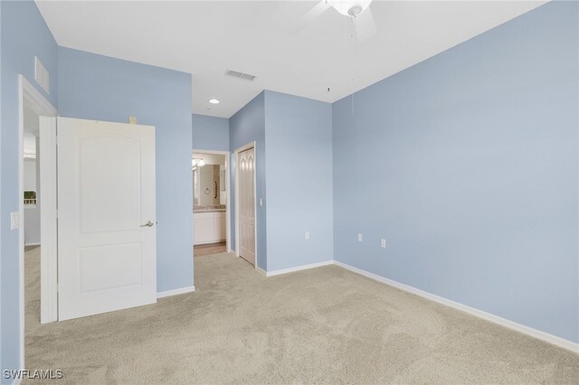unfurnished bedroom with carpet floors, baseboards, connected bathroom, and ceiling fan
