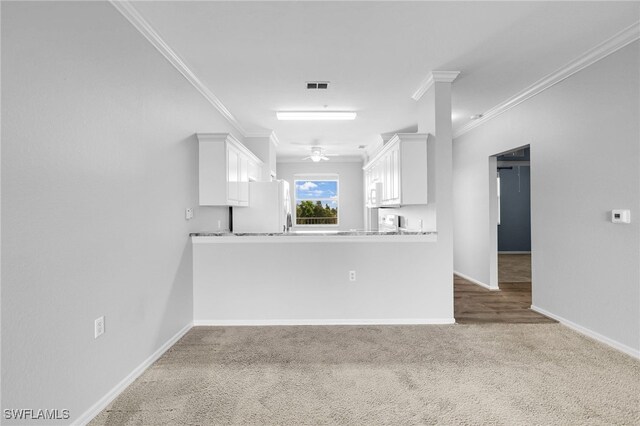 unfurnished living room featuring ornamental molding, carpet floors, baseboards, and a ceiling fan