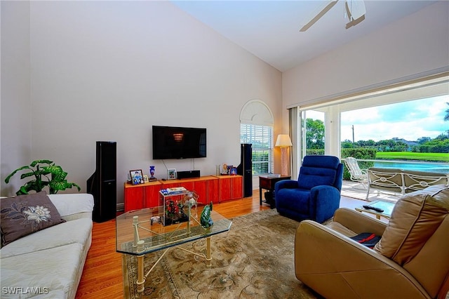 living room with wood finished floors, ceiling fan, and high vaulted ceiling
