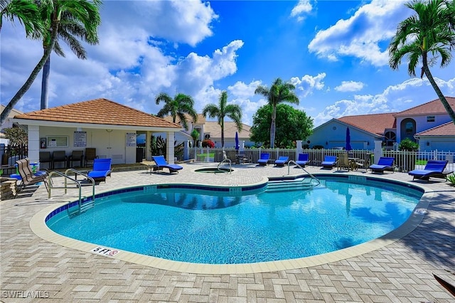community pool featuring a patio and fence
