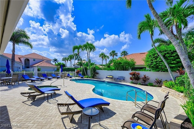 community pool with a fenced backyard and a patio area