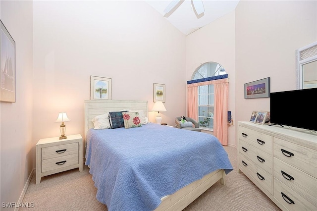 bedroom featuring light colored carpet, high vaulted ceiling, and baseboards