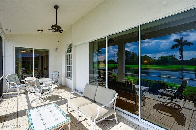 view of patio with ceiling fan and a water view