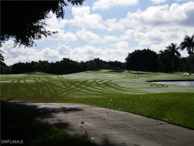 surrounding community featuring view of golf course and a lawn