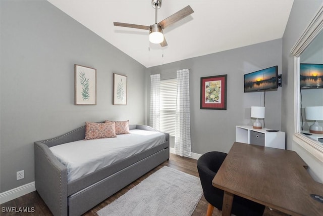 bedroom with baseboards, ceiling fan, wood finished floors, and vaulted ceiling
