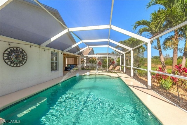 outdoor pool with a patio and glass enclosure