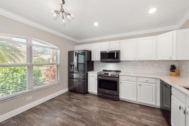 kitchen with backsplash, white cabinets, a chandelier, ornamental molding, and stainless steel appliances