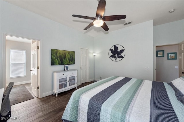 bedroom with a ceiling fan, baseboards, lofted ceiling, dark wood-type flooring, and visible vents