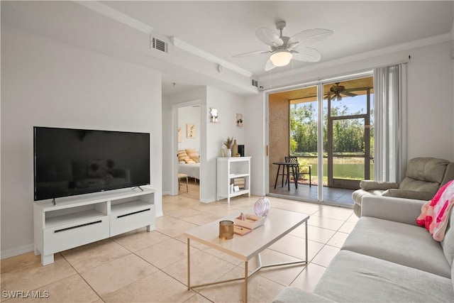 living room with crown molding, light tile patterned floors, visible vents, and a ceiling fan