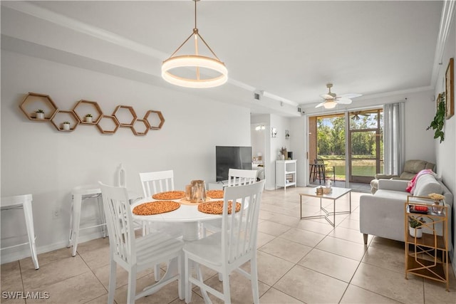 dining area featuring a ceiling fan, ornamental molding, and light tile patterned floors