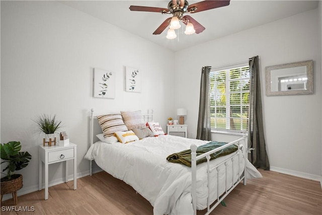 bedroom featuring ceiling fan, baseboards, and light wood-type flooring