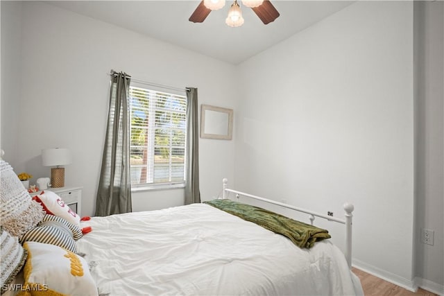 bedroom featuring a ceiling fan, wood finished floors, and baseboards